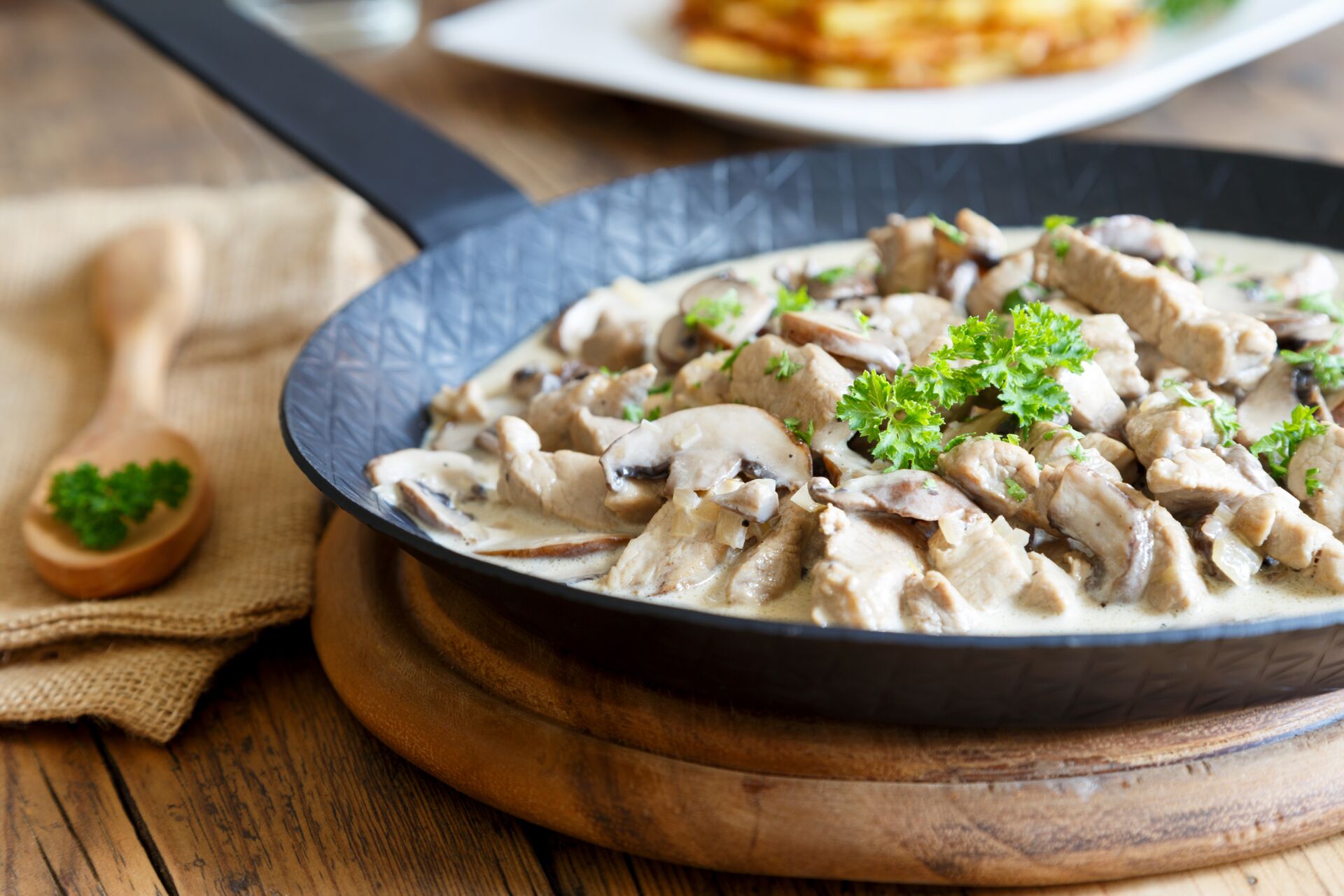 Züricher Geschnetzeltes mit Pilzen und dekoriert mit Petersilie in einer Pfanne
